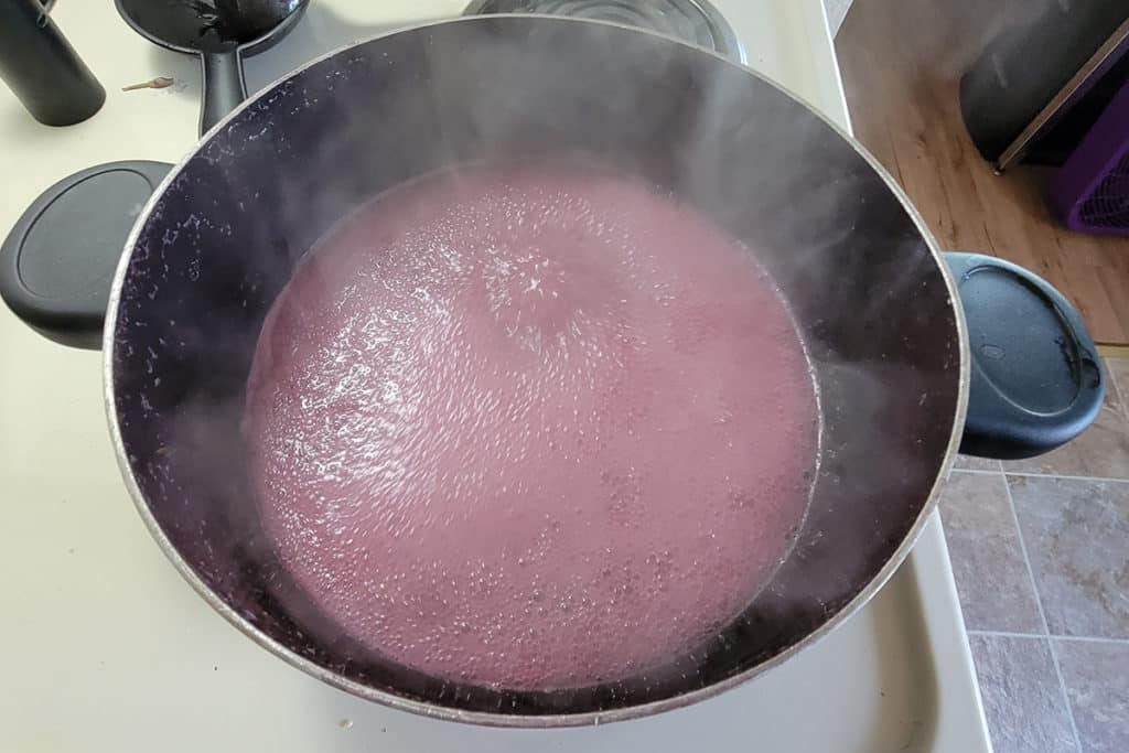 Boil the fireweed juice to start making the fireweed jelly