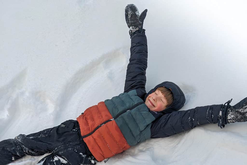 A Child Making A Snow Angel Smiling